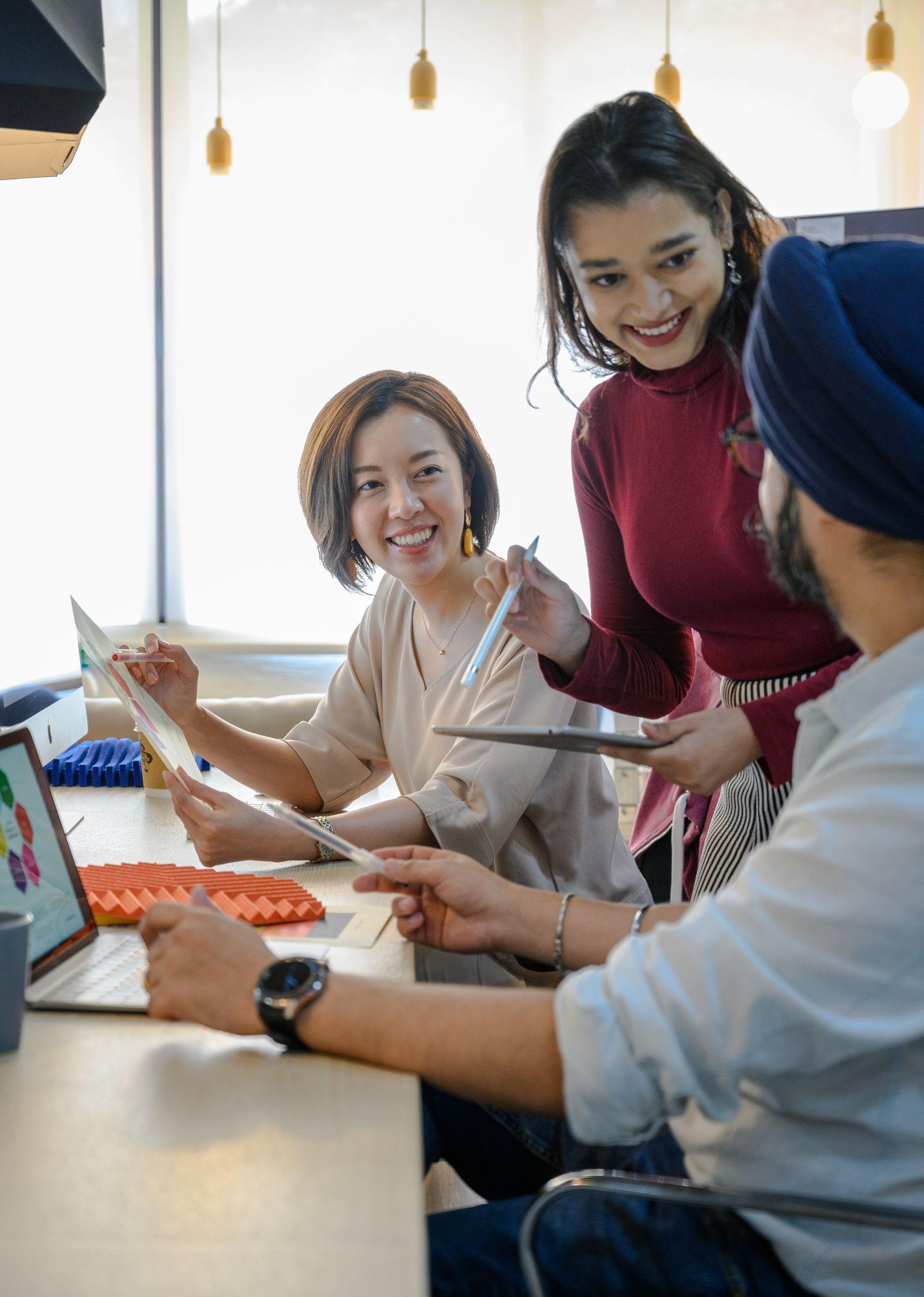 AI in presales: two colleagues reviewing data insights on a laptop in an office meeting