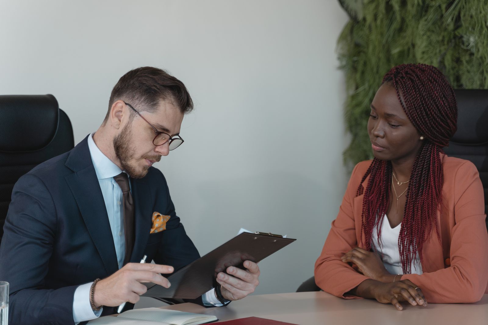 A hiring manager reviewing a job candidate resume during an interview in a modern office